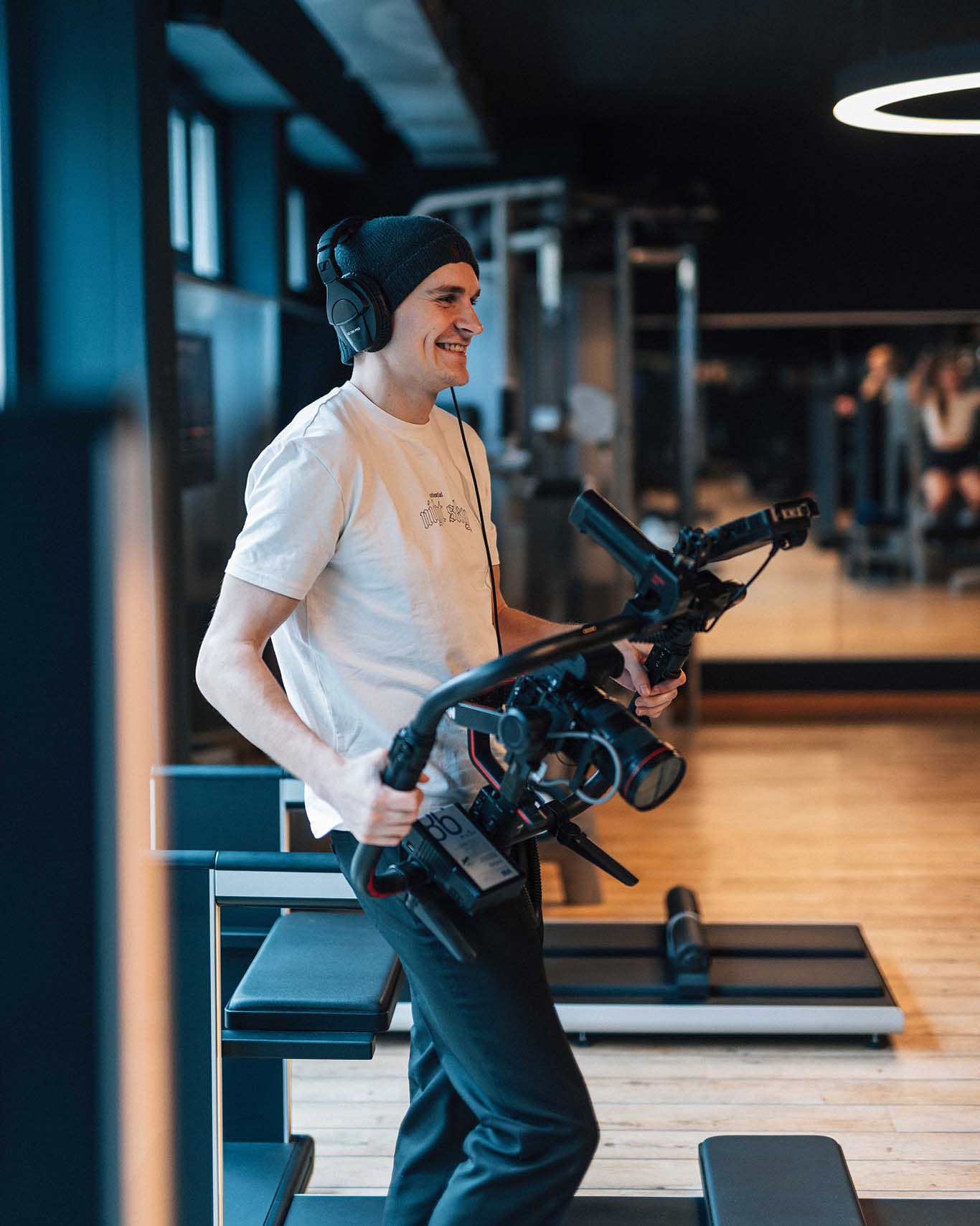 Videograph mit hochwertigem Kameraequipment in einem Fitnessstudio