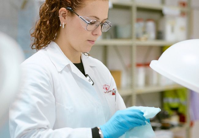 Frau im Chemielabor und weißem Kittel